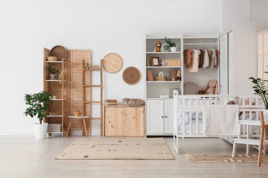 Bebek beşiği, dolap ve merdiveni olan ışık kreşinin içinde.