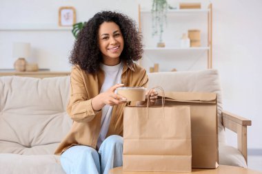 Genç Afro-Amerikalı kadın evdeki kese kağıdından konteynır alıyor. Yemek dağıtım servisi.