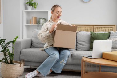 Genç bir kadın evdeki koltuktan yastık alıyor.