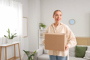 Evde paket kutusu olan genç bir kadın.