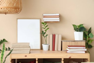 Bitkileri ve boş çerçeveleri olan kitaplar.