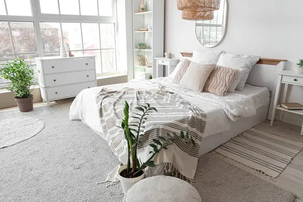 Rahat yatağı, çekmeceleri ve aynası olan şık bir yatak odası.