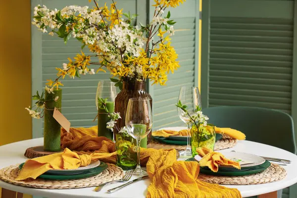 Çiçek açan dalları ve mumları olan masa ayarı