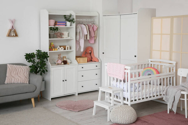 Interior of nursery with baby crib, closet and folding screen