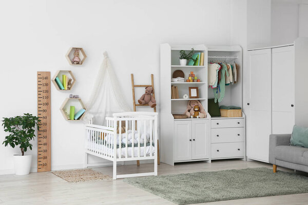Interior of nursery with baby crib, closet and ladder