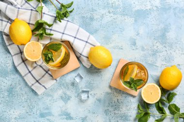 Mavi arka planda nane ve turunçgil meyveli limonlu buzlu çay.