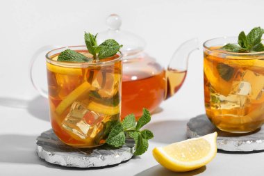 Çaydanlık ve bir bardak limonlu buzlu çay.