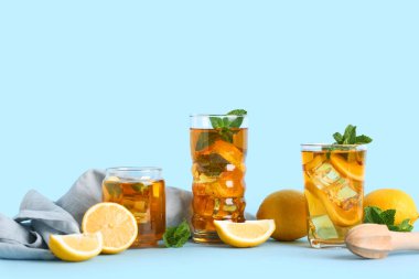 Mavi arka planda nane ve turunçgil meyveli limonlu buzlu çay.