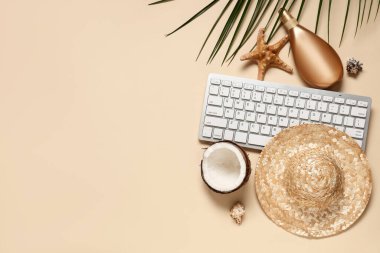 Bej arka planda şapka, güneş kremi ve plaj dekoru olan bilgisayar klavyesi
