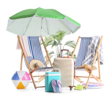 Yeşil plaj şemsiyeli çizgili güverte sandalyeleri ve beyaz arka planda izole edilmiş seyahat aksesuarları.