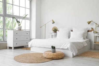 Beyaz çarşaflı, masalı ve lambalı aydınlatma odasının içinde.