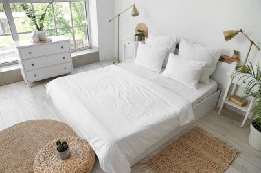 Beyaz çarşaflı, masalı ve lambalı aydınlatma odasının içinde.