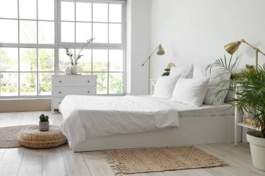 Beyaz çarşaflı, masalı ve lambalı aydınlatma odasının içinde.