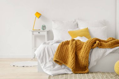 Yatak ve masa üzerinde beyaz çarşaf olan aydınlık odanın içinde.