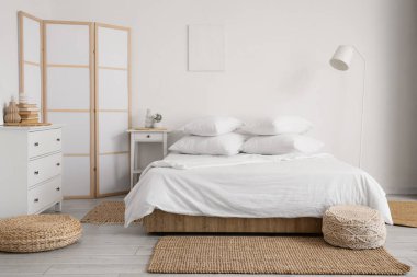 Yatak, masa ve katlama ekranlı beyaz çarşaflı aydınlatma odasının içi