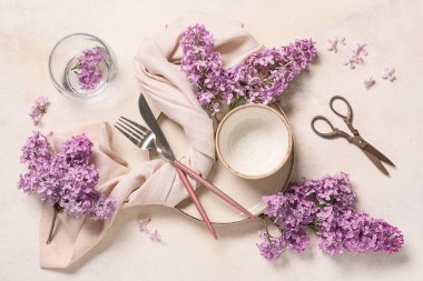 Beyaz arka planda leylak çiçekleri olan güzel bir masa.