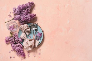 Pembe arka planda leylak çiçekleri olan güzel bir masa.