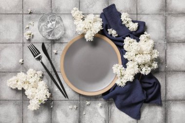 Gri arkaplanda beyaz leylak çiçekleri olan güzel bir masa.