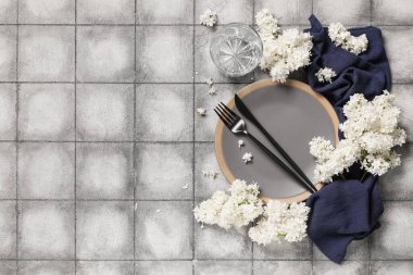 Gri arkaplanda beyaz leylak çiçekleri olan güzel bir masa.