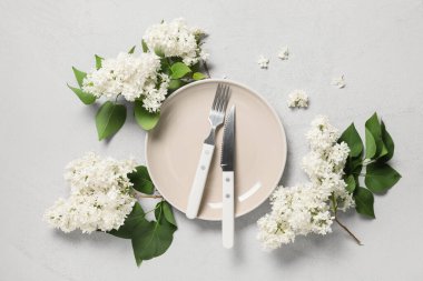 Gri arkaplanda beyaz leylak çiçekleri olan güzel bir masa.