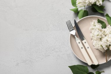 Gri arkaplanda beyaz leylak çiçekleri olan güzel bir masa.