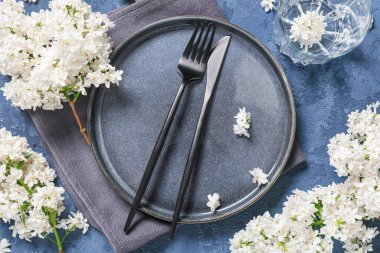 Mavi arka planda beyaz leylak çiçekleri olan güzel bir masa.