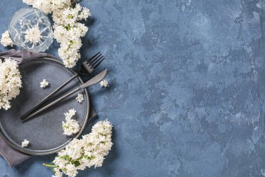 Mavi arka planda beyaz leylak çiçekleri olan güzel bir masa.