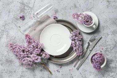 Gri arkaplanda leylak çiçekleri olan güzel bir masa.