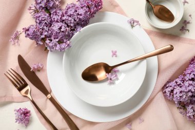 Beyaz arka planda leylak çiçekleri olan güzel bir masa.