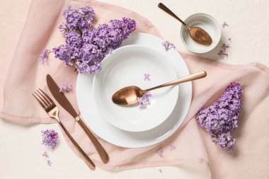 Beyaz arka planda leylak çiçekleri olan güzel bir masa.