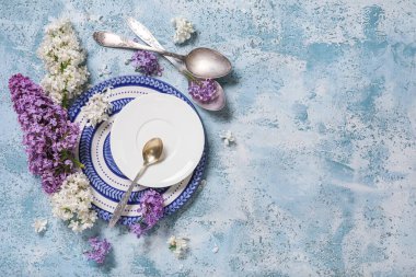 Mavi arka planda leylak çiçekleri olan güzel bir masa.