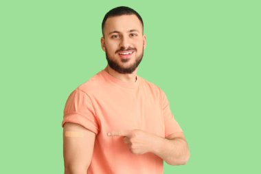 Yeşil arka planda uygulamalı tıbbi yaması olan genç bir adam. Dokunulmazlık kavramı