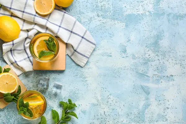 Mavi arka planda nane ve turunçgil meyveli limonlu buzlu çay.