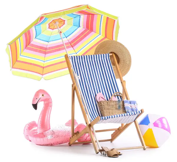 Renkli plaj şemsiyeli çizgili güverte sandalyesi ve beyaz arka planda izole edilmiş seyahat aksesuarları.