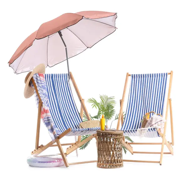 Plaj şemsiyeli çizgili güverte sandalyeleri ve beyaz arka planda izole edilmiş seyahat aksesuarları.