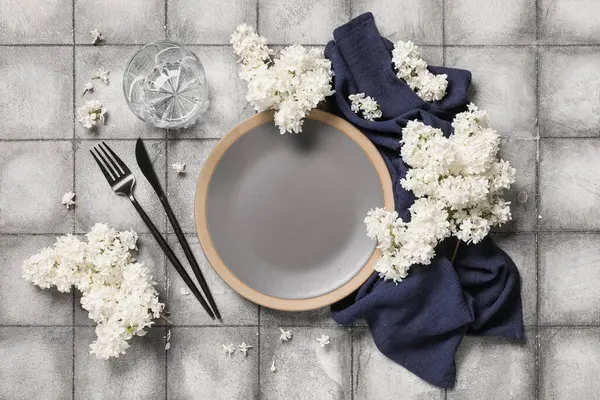 Gri arkaplanda beyaz leylak çiçekleri olan güzel bir masa.