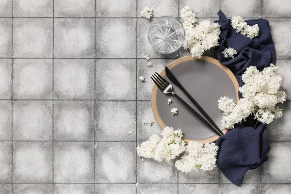 Gri arkaplanda beyaz leylak çiçekleri olan güzel bir masa.