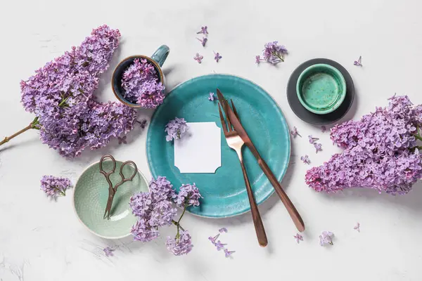 Boş kart ve beyaz arka planda leylak çiçekleri ile güzel masa ayarları