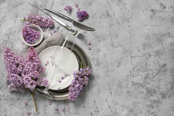 Gri arkaplanda leylak çiçekleri olan güzel bir masa.