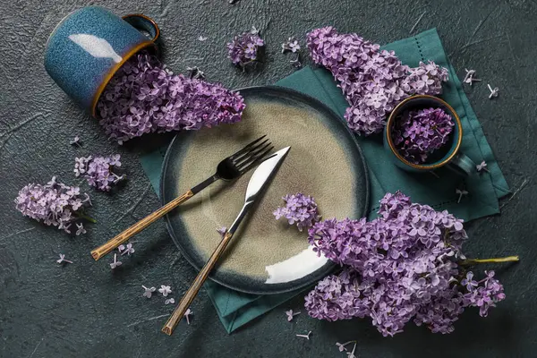Koyu arkaplanda leylak çiçekleri olan güzel bir masa.