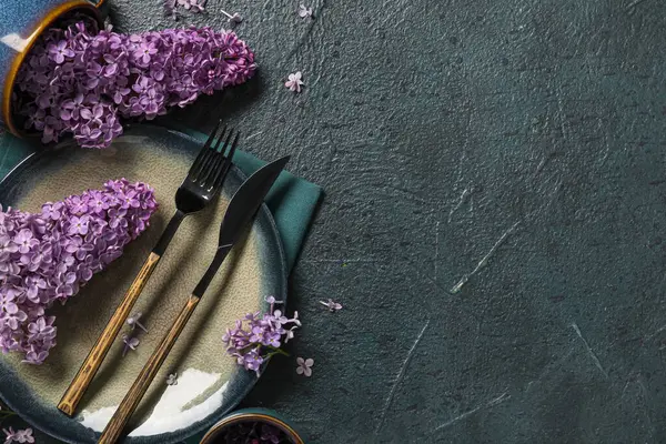 Koyu arkaplanda leylak çiçekleri olan güzel bir masa.