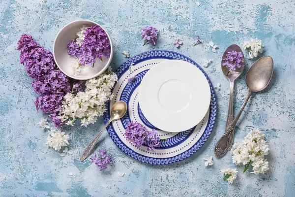 Mavi arka planda leylak çiçekleri olan güzel bir masa.