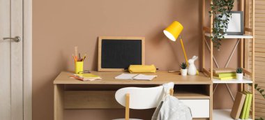 Odasında karatahta, lamba ve kırtasiye malzemesi olan bir öğrenci işyeri.