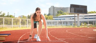 Stadyumda koşan genç bir bayan.