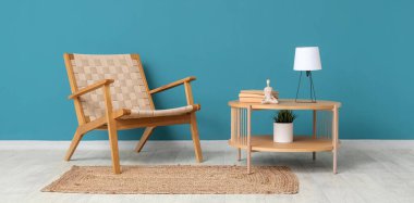 Koltuk ve kahve masası. Masa lambası mavi duvarın yanında.