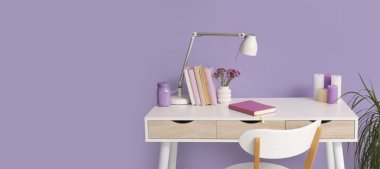 Lambası, kitapları ve aroma mumları olan modern bir iş yeri. Tasarım için pankart