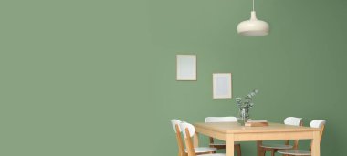 Vazoda okaliptüs dalları ve yemek odasının içinde kitaplar olan bir masa. Tasarım için pankart