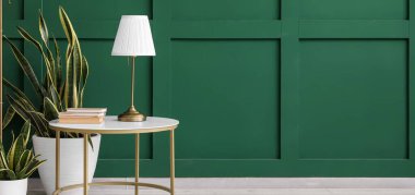 Kitapları, çiçekleri ve lambası olan modern masa.