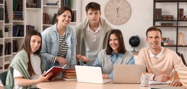 bir grup öğrenci kütüphanede okuyor.