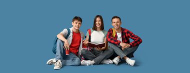 Mavi arka planda oturan bir grup öğrenci